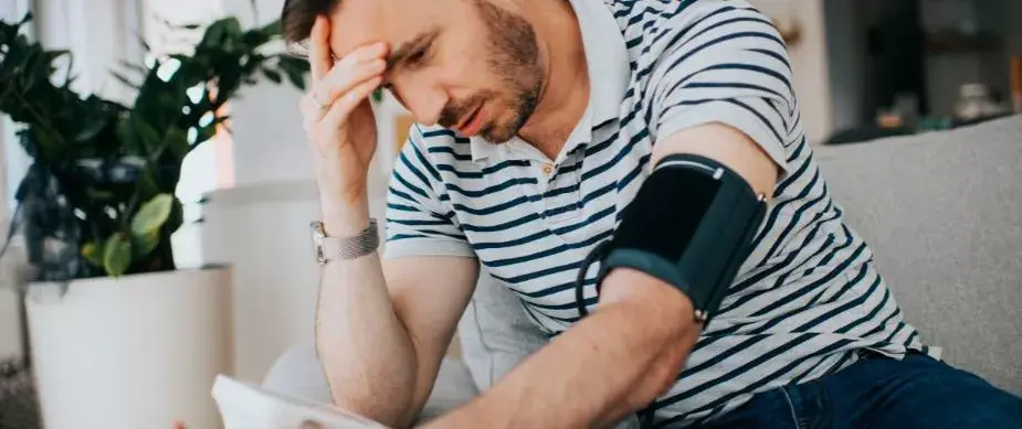 Pacient tanar cu hipertensiune arteriala care isi masoara tensiunea si acuza dureri de cap